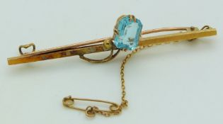 A 15ct gold brooch set with an emerald cut aquamarine, length 5cm