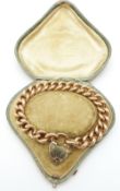 A 15ct rose gold curb link bracelet with padlock clasp, in original box, 28.1g