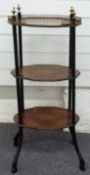 Three tier inlaid marquetry what-not with ebonised frame set with ornate brass finials, the top tier