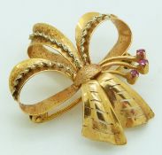 A 18ct gold pendant/ brooch in a bow set with rubies, 6.5g