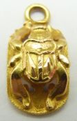 A yellow metal charm in the form of a scarab beetle, 0.4g