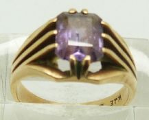 A 9ct gold ring set with an emerald cut purple sapphire, 5.2g, size O