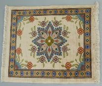 Turkish miniature silk rug with floral decoration on a cream ground, 27 x 22 cm.