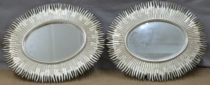 A pair of decorative oval mirrors with silver sunburst style frames, each 97 x 80cm