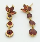 A pair of 14k gold earrings set with garnets