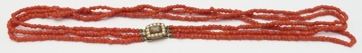 A three strand coral necklace with a Victorian clasp set with pearls and hair