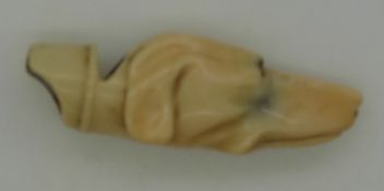 A 19thC ivory novelty whistle carved in the form of a dog's head, length approximately 5cm