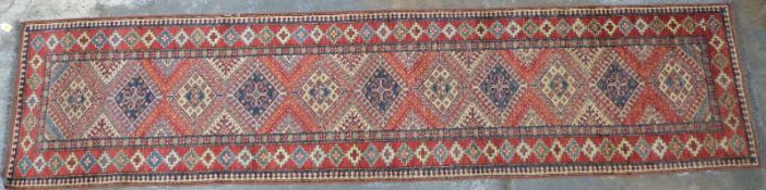 Runner with red ground and blue and cream decoration, 330 x 78cm