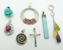 A silver pendant set with a ruby cabochon and six silver pendants