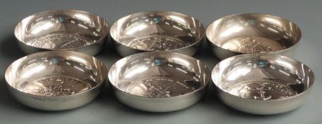 Six white metal bowls or pin dishes with applied medallions to bases, marked to underside of one
