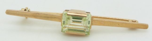 A 14k gold brooch set with a rectangular spinel