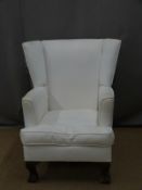 White upholstered chair raised on ball and claw feet