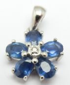 A 14k white gold pendant set with a diamond and sapphires