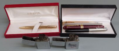 A collection of pens including Sheaffer and Parker together with two Zippo lighters.