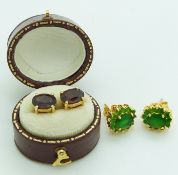 A pair of 18ct gold earrings set with garnets and another pair set with a cluster of green stones