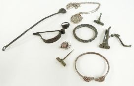 A silver bangle with ram head decoration, silver spider charm, Roman bottle spoon, Roman fibula