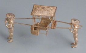 Chinese white metal novelty model of two men carrying a chair with filigree roof and seat, with