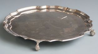Large hallmarked silver salver with shaped edge and raised on four scroll feet, Birmingham 1973