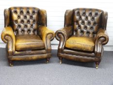 Two Chesterfield button back, club style arm chairs finished in chestnut brown / tan leather with