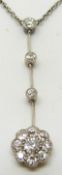 An 18ct white gold pendant / necklace set with three drop diamonds leading to a diamond cluster, 5g
