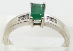 A 14k white gold ring set with an emerald cut emerald and diamonds to the shoulders, 3.6g, size N