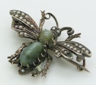 A silver insect brooch set with seed pearls and two cat's eye cabochons, 3 x 4.2cm