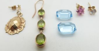 Two emerald cut aquamarines each approximately 2.5cts, a yellow metal earring set with peridot,