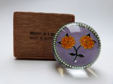A William Manson 'weight in a crate' paperweight with lampwork flower on mauve ground with signature