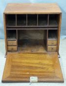 An oak table top stationery box with lockable fall flap opening to reveal an arrangement of cubby