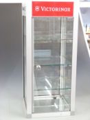 A glazed and brushed steel haberdashery/shopfitting display cabinet with Maglite and Victorinox