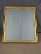 A large bevelled glass mirror W106 x 91cm