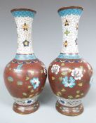 A pair of 19thC/ ealy 20thC cloisonné vases with bird and floral decoration, 21.5cm tall