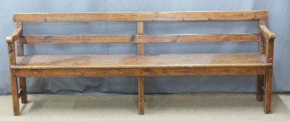 A 19thC pine pew raised on six legs united front to back by simple wooden strainers, ex Cinderford