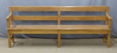 A 19thC pine pew with back shelf/prayer book rest raised on six legs united front to back by