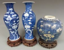 Chinese 19th/20thC prunus ginger jar (15cm tall) a pair of a prunus vases and hardwood stands (