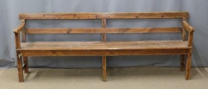A 19thC pine pew raised on six legs united front to back by simple wooden strainers, ex Cinderford