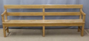 A 19thC pine pew with back shelf/prayer book rest raised on six legs united front to back by
