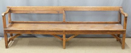 A 19thC pine pew raised on six legs united front to back by simple wooden strainers, ex Cinderford