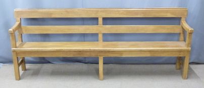 A 19thC pine pew with back shelf/prayer book rest raised on six legs united front to back by