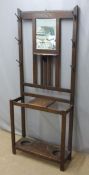 An oak hall stand with mirror and umbrella / stick wells, W76 x D25 x H187cm