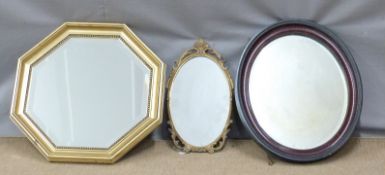 Oval and octagonal bevelled glass mirrors, largest 63cm