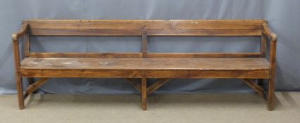 A 19thC pine pew raised on six legs united front to back by simple wooden strainers, ex Cinderford