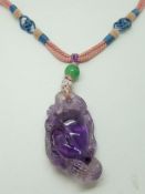 Chinese carved amethyst pendant depicting a peach, with triangular mark to both sides, on Chinese