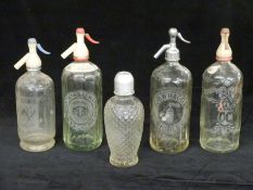 Five vintage soda siphon bottles including W Biscombe Plymouth, Cambrian Mineral Water Co Bolton,