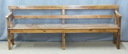 A 19thC pine pew raised on six legs united front to back by simple wooden strainers, ex Cinderford