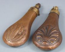 Two copper and brass powder flasks, both with embossed decoration to each side, largest 19cm long.