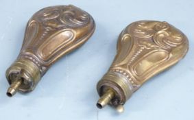 Two copper and brass pistol or revolver powder flasks both with embossed decoration to both sides,