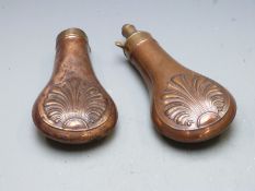 Two copper and brass powder flasks both with embossed decoration to both sides, largest 20cm long.