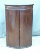 19thC bow fronted inlaid mahogany corner cupboard, W65 H100cm