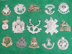 A small collection of British military cap badges including Royal Sussex Regiment, The King's Own